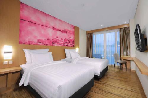 Un pat sau paturi într-o cameră la favehotel Nagoya - Batam