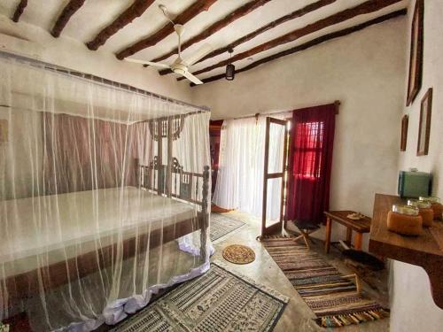 1 dormitorio con cama con dosel en una habitación en MARS A.K. VILLAS, en Jambiani