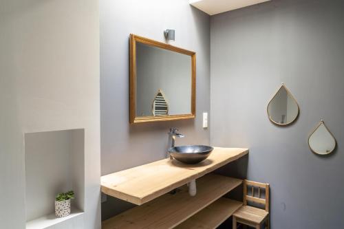 une salle de bain avec un lavabo et un miroir dans l'établissement Charmante maison plain-pied et son jardin fleuri, à Nantes