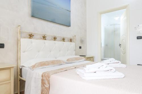 a bedroom with a white bed with towels on it at Blue And Blue City in Ugento
