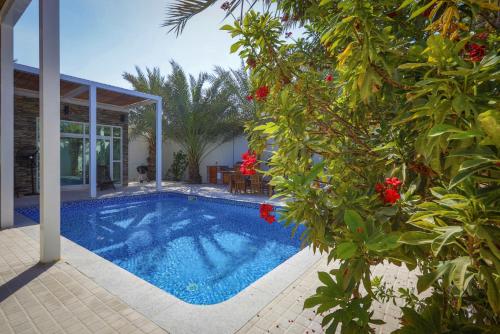 a swimming pool in front of a house at Dar 66 Pool Chalets with Jacuzzi in Ras al Khaimah