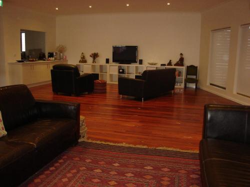 a living room with couches and a flat screen tv at Crossroads Ecomotel in Port Augusta
