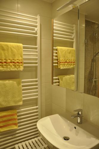 ein Badezimmer mit einem Waschbecken, einem Spiegel und Handtüchern in der Unterkunft Haus Kocher in Haus im Ennstal