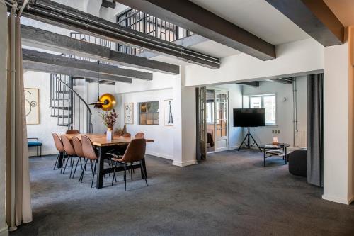 a dining room with a table and chairs and a television at The Churchill Penthouse by Daniel&Jacob's in Copenhagen