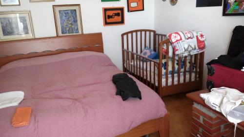 a bedroom with a pink bed and a crib at Cinque Terre Tra Il Filo Di Arianna in Riccò del Golfo di Spezia