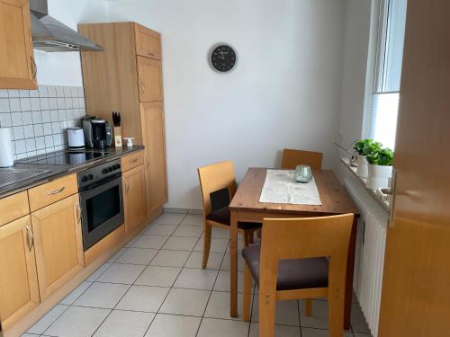 a small kitchen with a wooden table and chairs at Ferienwohnung Dieblich an der Mosel in Dieblich