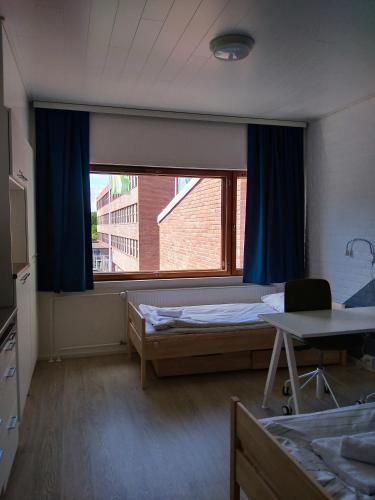 a room with two beds and a large window at Harju Apartments in Jyväskylä