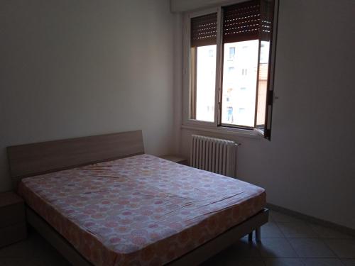 a bedroom with a bed in a room with a window at Niguarda Alfred House in Bresso