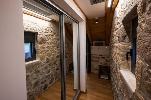 a room with a stone wall and sliding glass doors at Villa Terra Alta in Zakharo