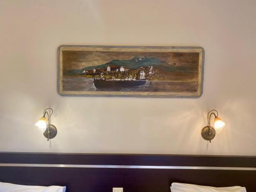 een schilderij van een boot op een muur met twee lichten bij Hotel Alkionis in Ierissos