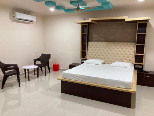 a bedroom with a bed and two chairs and a table at Hotel City View in Bhubaneshwar