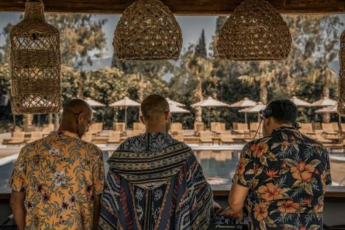 a group of three men standing in front of a pool at Cook's Club Corfu - Adults Only in Gouvia
