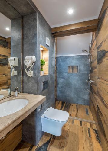 a bathroom with a toilet and a sink at Хотел Камъните in Burgas