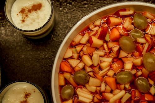 a table with a pan of vegetables and a drink at Cook's Club Corfu - Adults Only in Gouvia