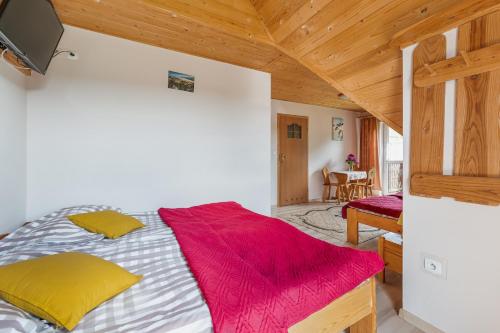 a bedroom with a bed with a red blanket at Pokoje nad Czarną Wodą Agroturystyka in Jaworki