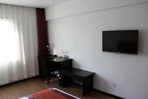 Zimmer mit einem Schreibtisch und einem TV an der Wand in der Unterkunft Super 8 Beijing Chaoyang Road Xinglong in Peking