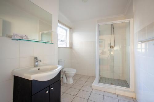 a bathroom with a sink and a shower and a toilet at Inverdoorn Game Reserve Lodge in Breede River DC