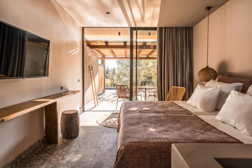 a bedroom with a bed and a tv and a patio at Cook's Club Corfu - Adults Only in Gouvia