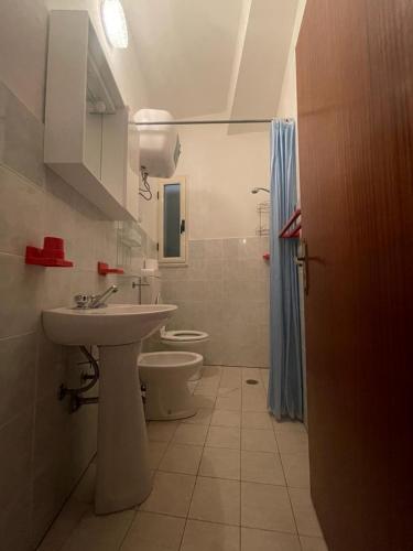 La salle de bains est pourvue d'un lavabo et de toilettes. dans l'établissement Alba Holiday House , Casa Vacanze Ricadi, à Santa Maria
