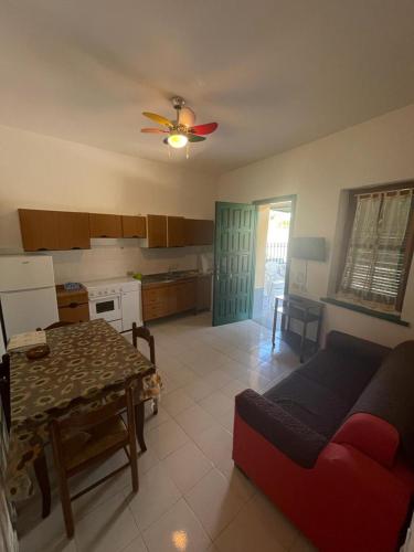 eine Küche mit einem roten Sofa und einem Tisch in einem Zimmer in der Unterkunft Alba Holiday House , Casa Vacanze Ricadi in Santa Maria