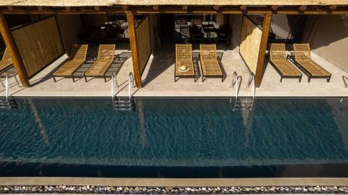 a row of chairs next to a swimming pool at Cook's Club Corfu - Adults Only in Gouvia