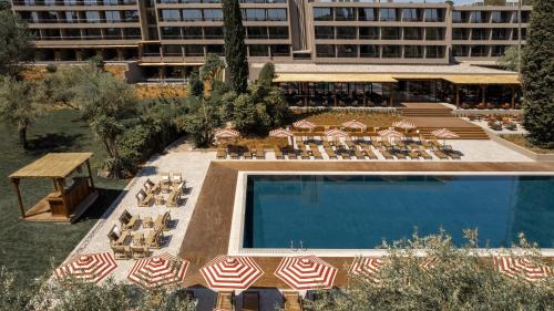 an overhead view of a pool with chairs and umbrellas at Cook's Club Corfu - Adults Only in Gouvia