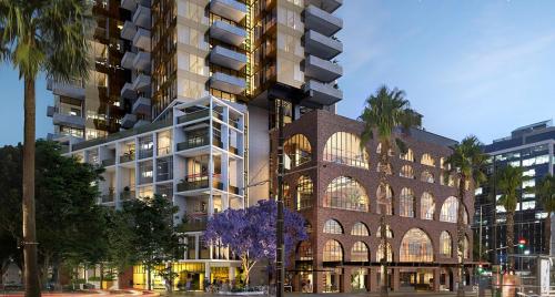a tall building with a purple tree in front of it at Lovely waterfront condo with swimming pool and gym in the heart of Docklands in Melbourne