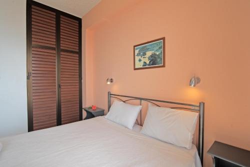 a bedroom with a bed with white pillows at Andromaches apartment sea view in Achílleion
