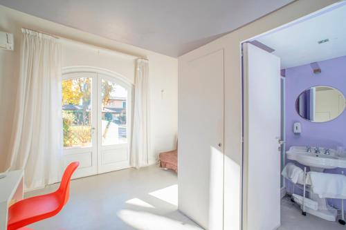 baño con silla roja y lavamanos en Hotel Villaggio Le Stelline, en Montefalco