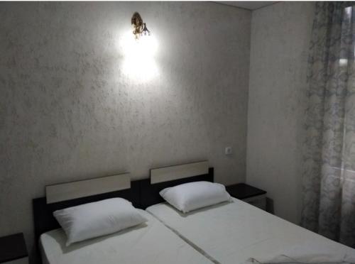 a bedroom with two beds and a light on the wall at Вилла Блюз in Novy Afon