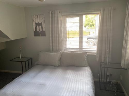 a white bed in a room with a window at Wellbrook Rooms in Tring