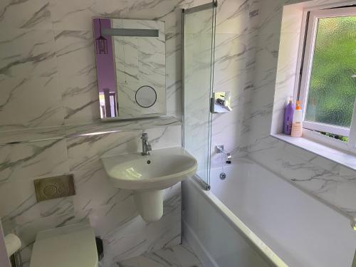 a white bathroom with a sink and a bath tub and a sink at Wellbrook Rooms in Tring
