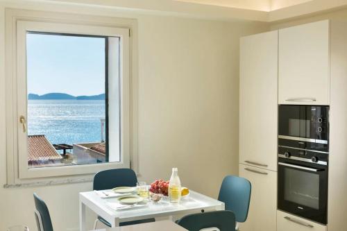 a kitchen with a white table and chairs and a window at Centro Storico, meravigliosa vista mare, 4' piano senza ascensore in Alghero