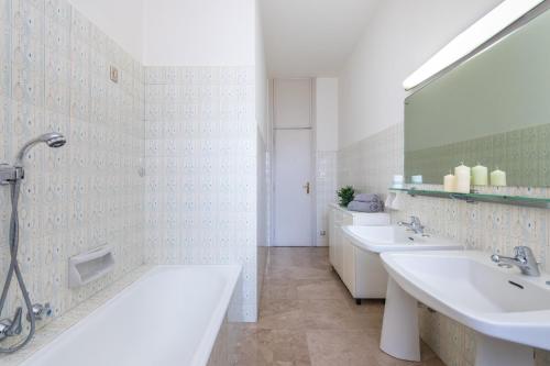 a bathroom with two sinks and a large mirror at Crocetta Family Apartment by Wonderful Italy in Turin