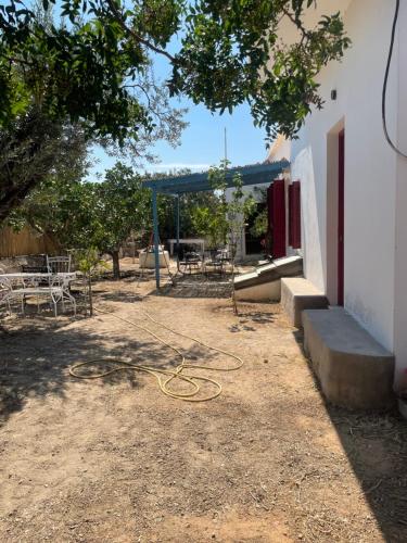 un patio con un cobertizo con una manguera en el suelo en Fishermans House en Khlóï