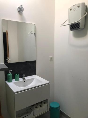 une salle de bain blanche avec un lavabo et un miroir dans l'établissement Duplex en Pierre Proche des Arenes, à Arles