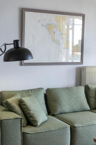 a living room with a couch and a map on the wall at Paleokastritsa Red Gate Flat in Paleokastritsa
