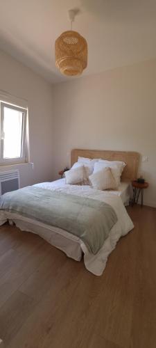 une chambre blanche avec un grand lit avec des oreillers dans l'établissement Charmant T2 coeur de village avec stationnement, à Banyuls-sur-Mer