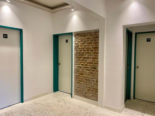 a room with two doors and a brick wall at BE BOLD HOSTEL in Antalya