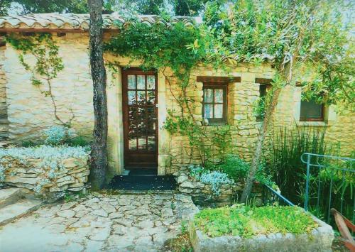 una casa de piedra con una puerta en un patio en Le Mazet en Souvignargues