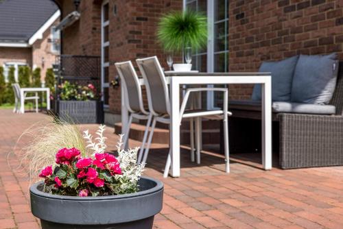 a patio with a table and chairs and flowers at VILLA AIDO in Palanga