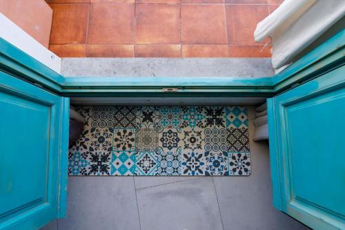 a bathroom with a tiled floor and blue doors at Hostal Boutique Olvido 22 Adults Only in Peñíscola