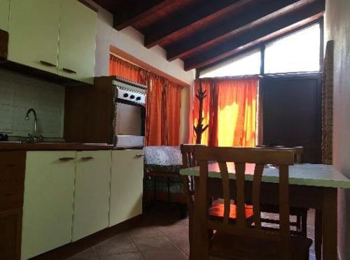 uma cozinha com uma mesa, um lavatório e uma janela em Il Nido delle Gazze em Marina di Camerota