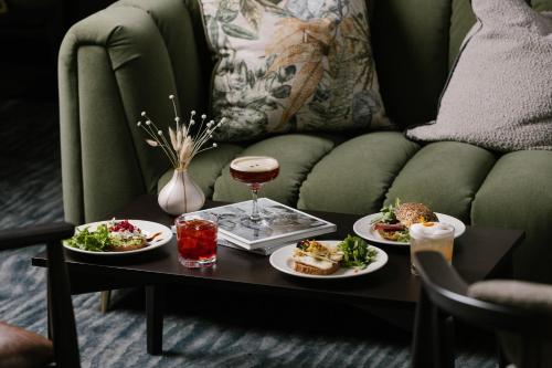 爱丁堡Heeton Concept Aparthotel Edinburgh Queen Street的一张桌子,上面放着两盘食物和一杯葡萄酒