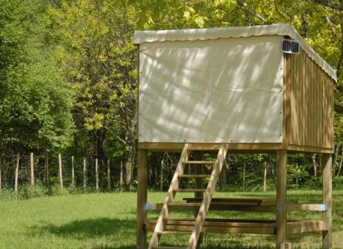 une structure en bois avec un couvercle sur l'herbe dans l'établissement Les étoiles du brochet, à Péronne