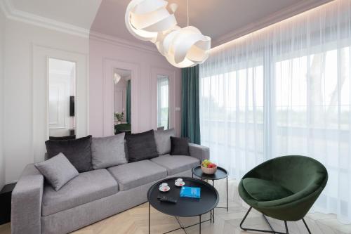 a living room with a couch and a green chair at Apartamenty The View Hevenia in Rewal