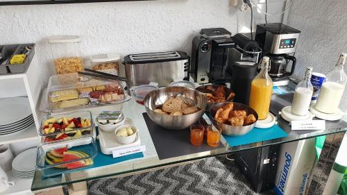 Casa Rainbow - Boutique Bed & Breakfast في موجاكار: طاولة طعام ومشروبات على طاولة