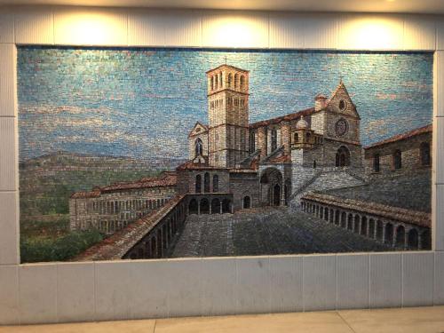 a mosaic mural of a church with a tower at Assisi Luxury SPA Suite Superior in Assisi