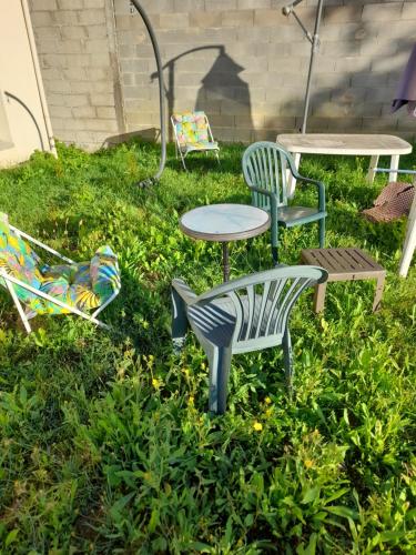 un groupe de chaises et de tables dans l'herbe dans l'établissement Plusieurs chambres à 20 km au sud de Paris, à Ballainvilliers