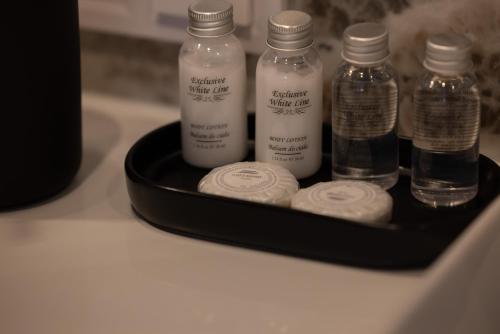 a black tray with four bottles of medicine on a counter at Apartamenty The View Hevenia in Rewal